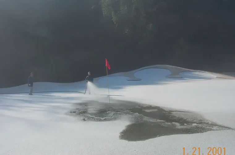 Using irrigation water to melt snow from putting greens so the course could open.