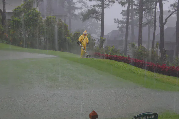 Cutting grass on a rainy day in Baguio, Philippines.