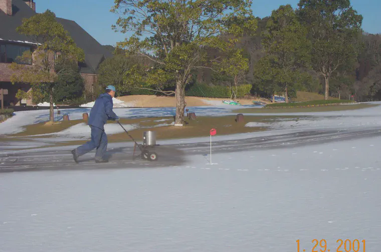 Spreading charcoal powder on the practice putting greens at Habu CC.