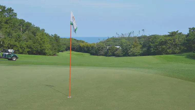 Looking from the 11th green at Keya GC toward the tee and the Genkai-nada Sea in the background.