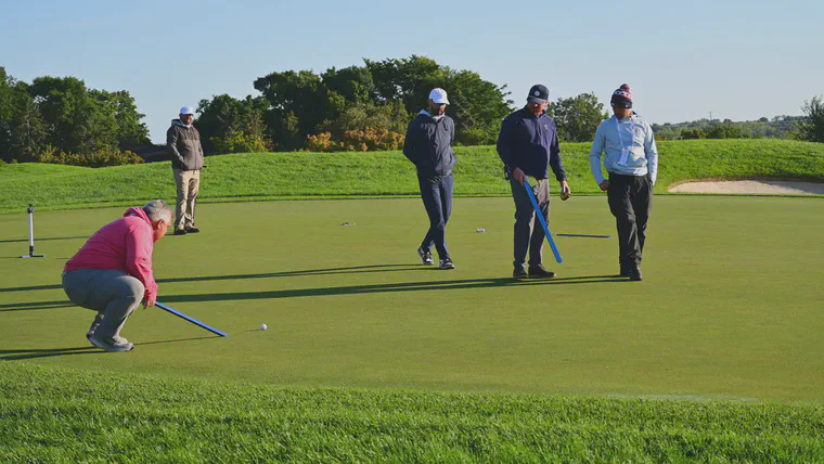 Assessing ball roll with the stimpmeter on the ninth green during the 2024 U.S. Amateur Championship at Hazeltine National Golf Club.