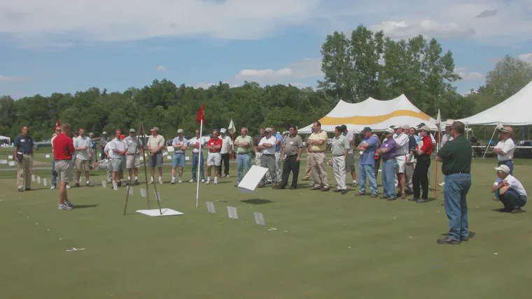 At the Cornell Turfgrass Field Day in June 2003, I'm standing (speaking, in shorts and a red shirt) on plots where I was conducting a potassium and soil testing experiment; to my left (north) are the plots with the different fertilizer treatments discussed here.