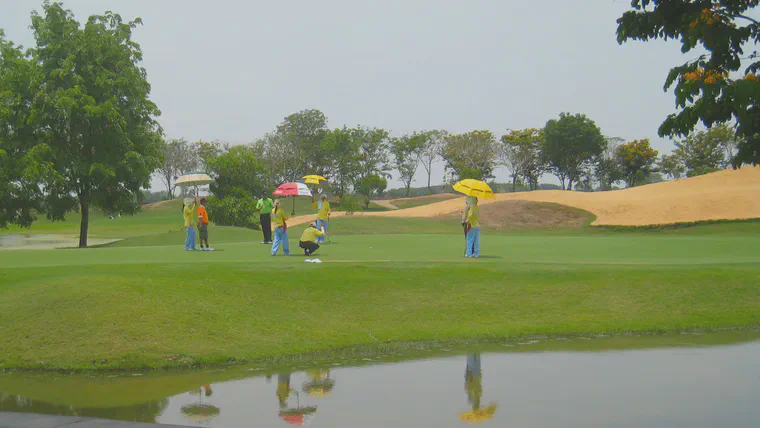 Caddies and golfers at Bangsai CC north of Bangkok use umbrellas to provide shade on a sunny summer day
