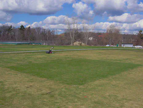L-93 creeping bentgrass in the center of the image at Ithaca, NY on 8 April 2005. No snow mold fungicides were applied to any of the turf, and the green rectangle was fertilized using small amounts of nitrogen in the autumn of 2004; the surrounding areas had fertilizer stopped earlier in the autumn.